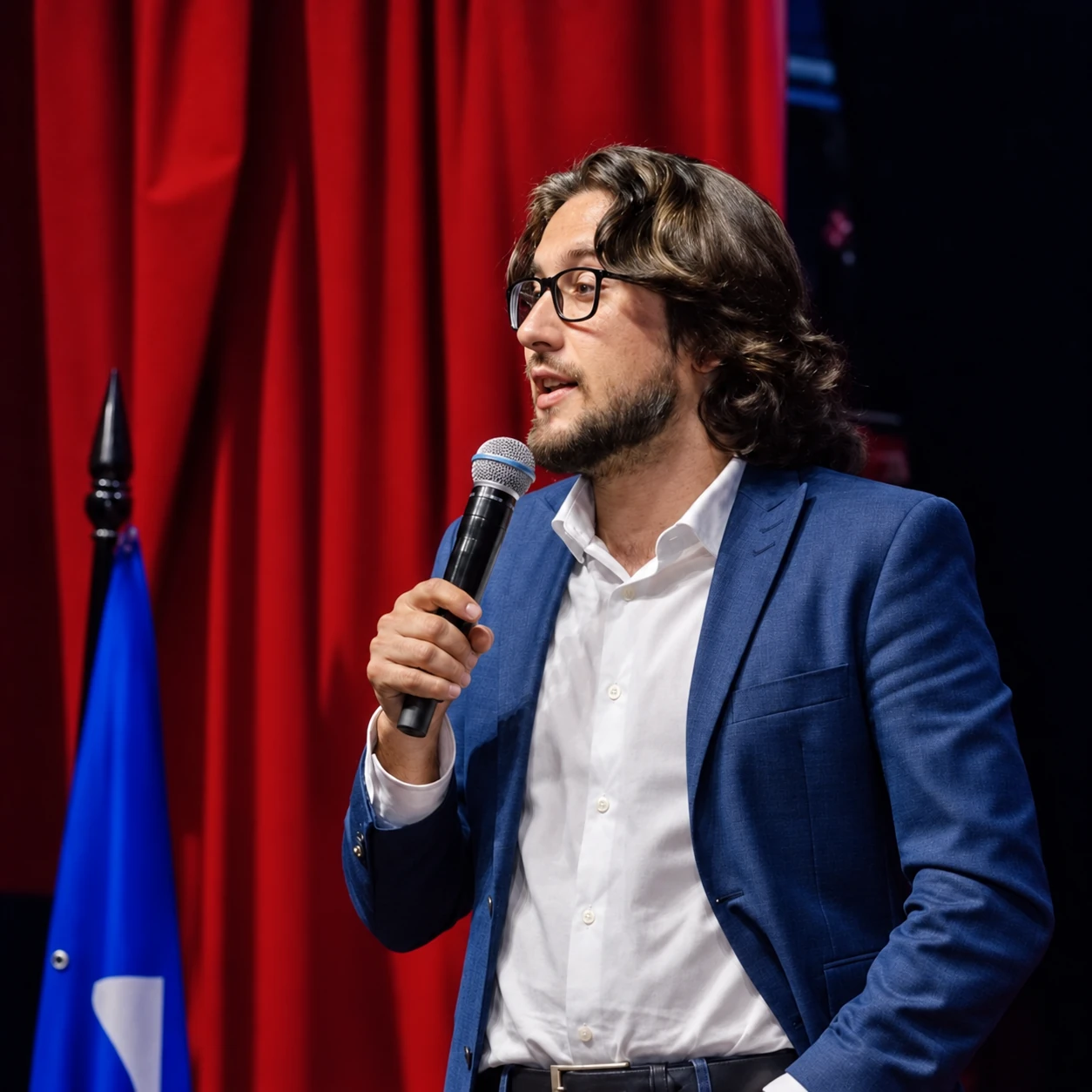 Douglas Remonatto falando ao microfone, com blazer azul